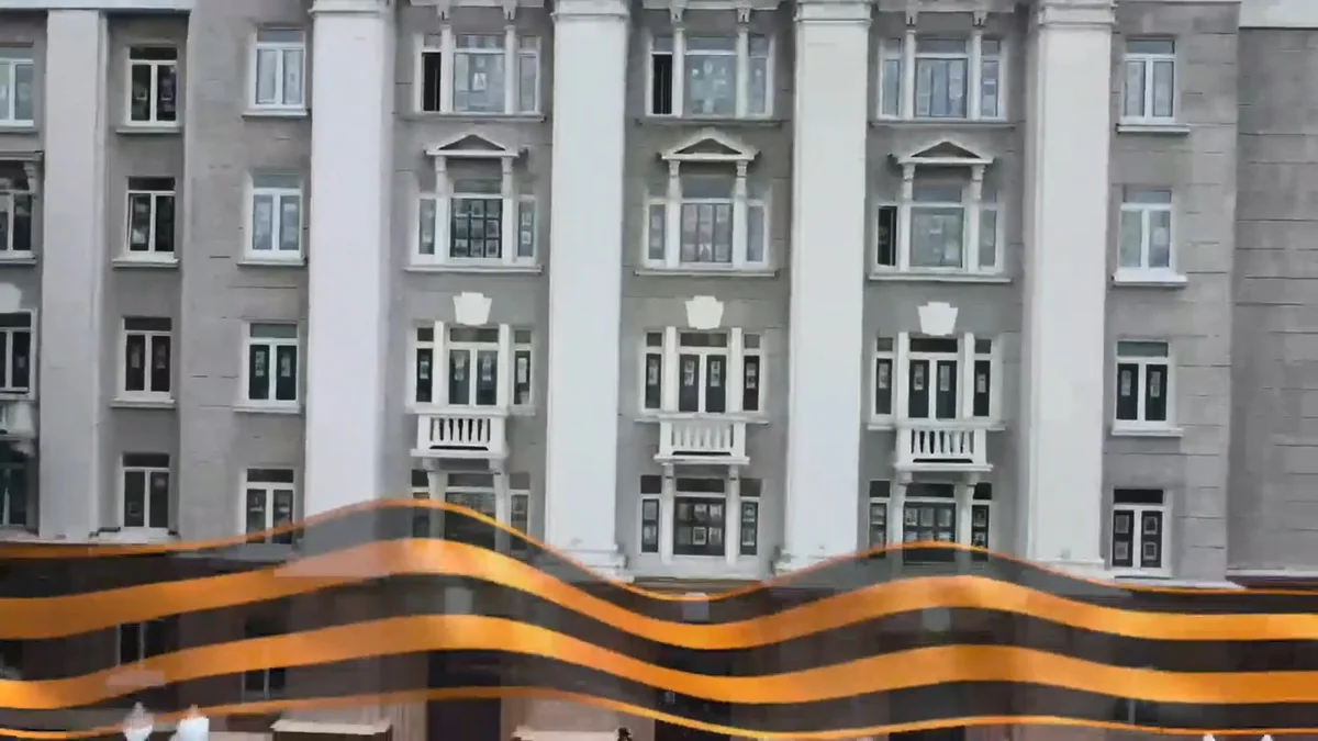 Здание с портретами ветеранов в окнах и Георгиевской лентой